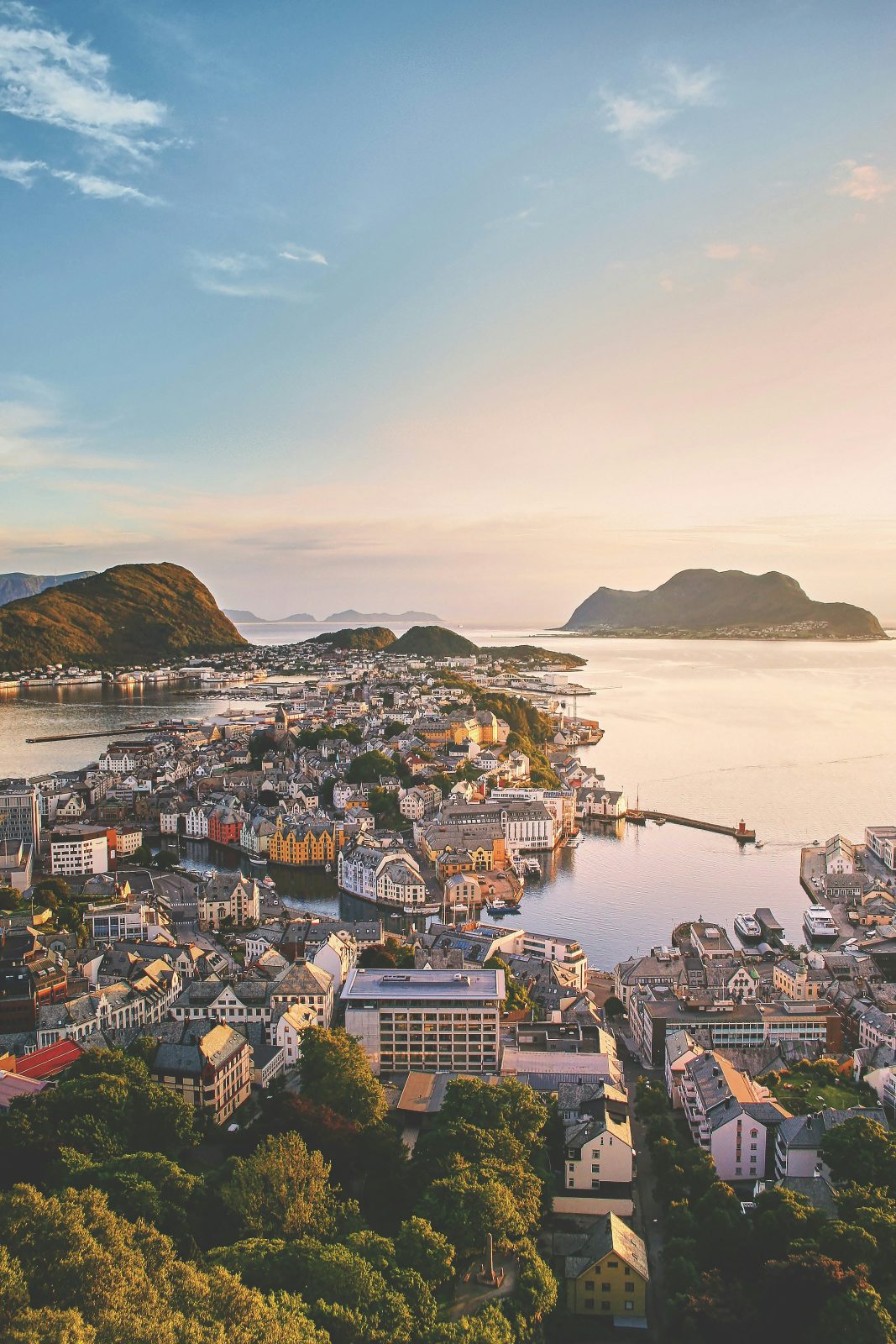 Ålesund sentrum utover øyene i gyllent kveldslys, sett fra Aksla, med hav og øyer i horisonten