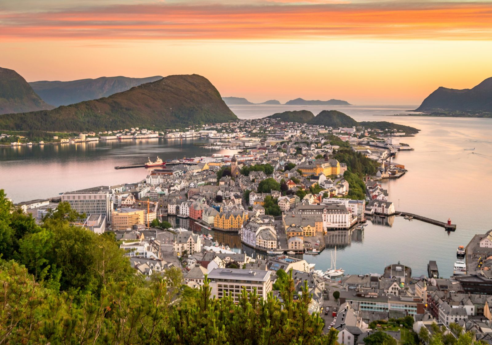 Solnedgang over Ålesund sett fra Aksla, med byen, havna og fjellene i oransje lys