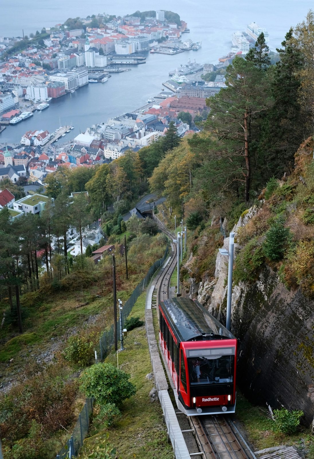 Fløibanens røde vogn «Rødhette» på vei ned skinnegangen, med Bergen sentrum og havnen langt der nede