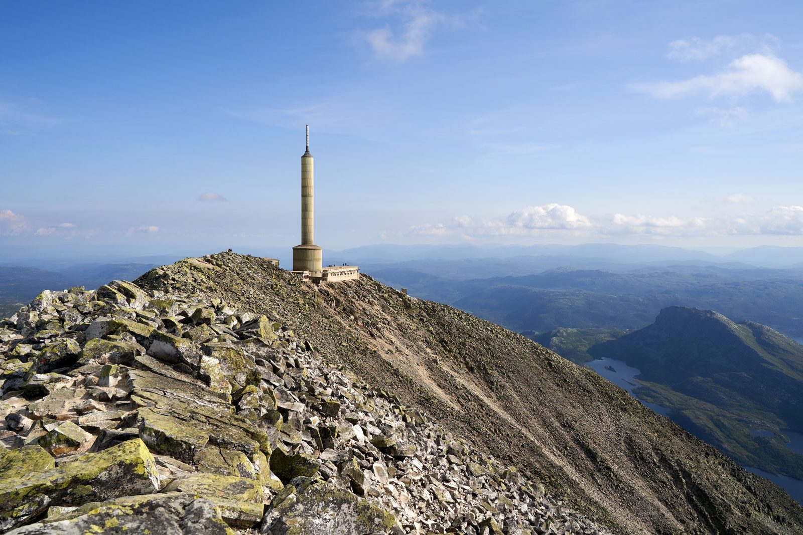 Toppryggen på Gaustatoppen med radiotårnet og turisthytta, steinete terreng og milevid utsikt over Telemark