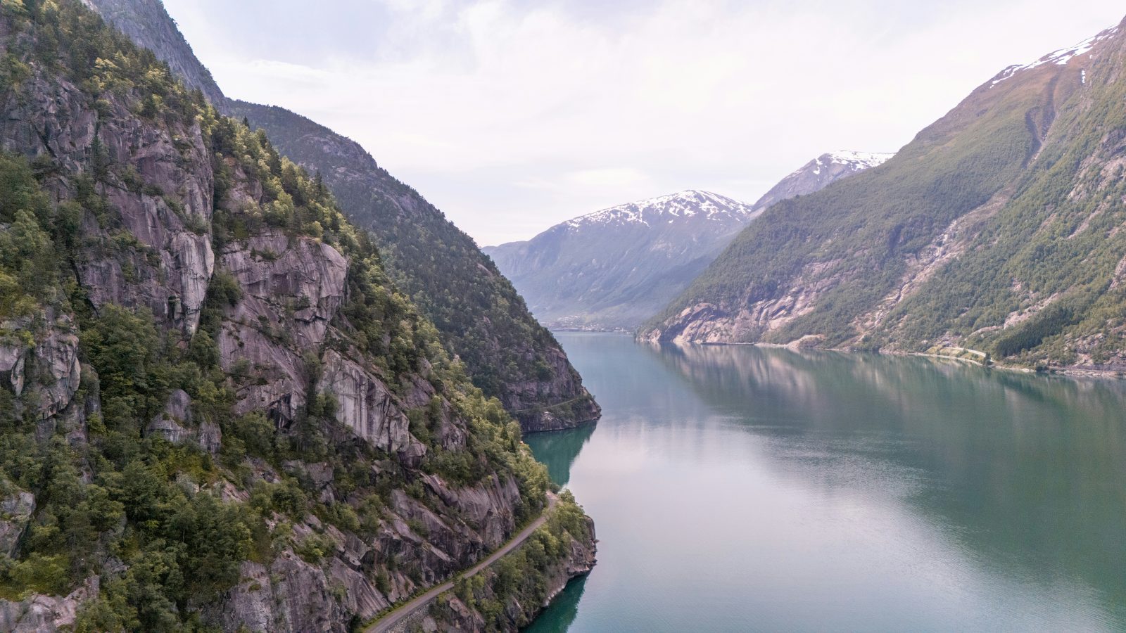 En trang arm av Hardangerfjorden med veien skåret inn i den bratte fjellsiden like over vannet