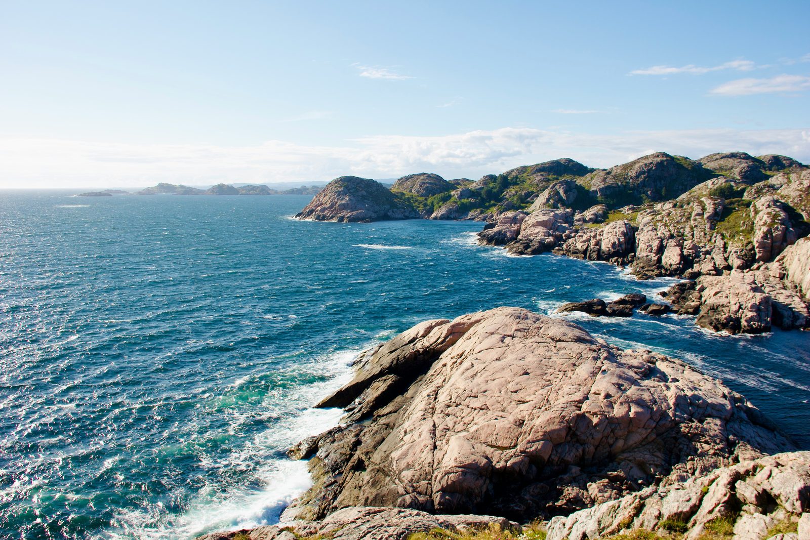 Svaberg og skjærgård ytterst på Lindesneshalvøya, med havet i kraftig bevegelse
