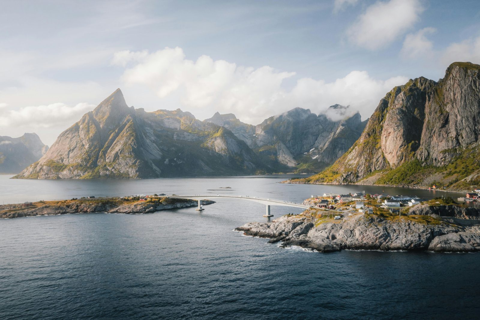 Broen mellom Hamnøy og Olenilsøya i Lofoten, med spisse fjell rundt Reinefjorden i sommerlys