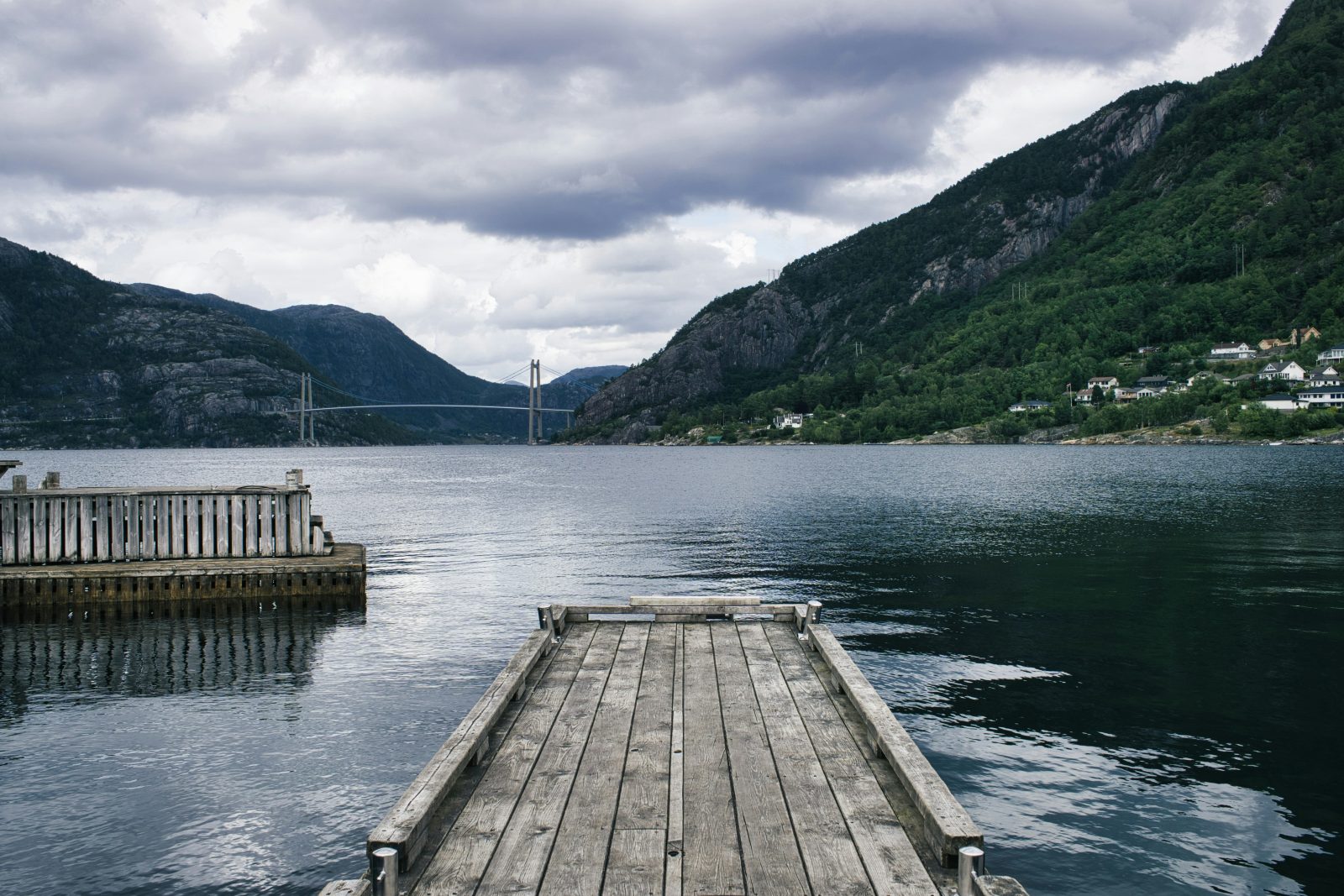 Trebrygge ved Forsand med utsikt innover Lysefjorden, med Lysefjordbrua spent over fjordmunningen i bakgrunnen