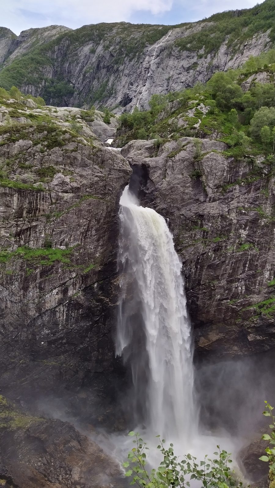 Månafossen kaster seg i ett fritt fall ned i det trange juvet, med Frafjordheiane og de grå fjellsidene bak