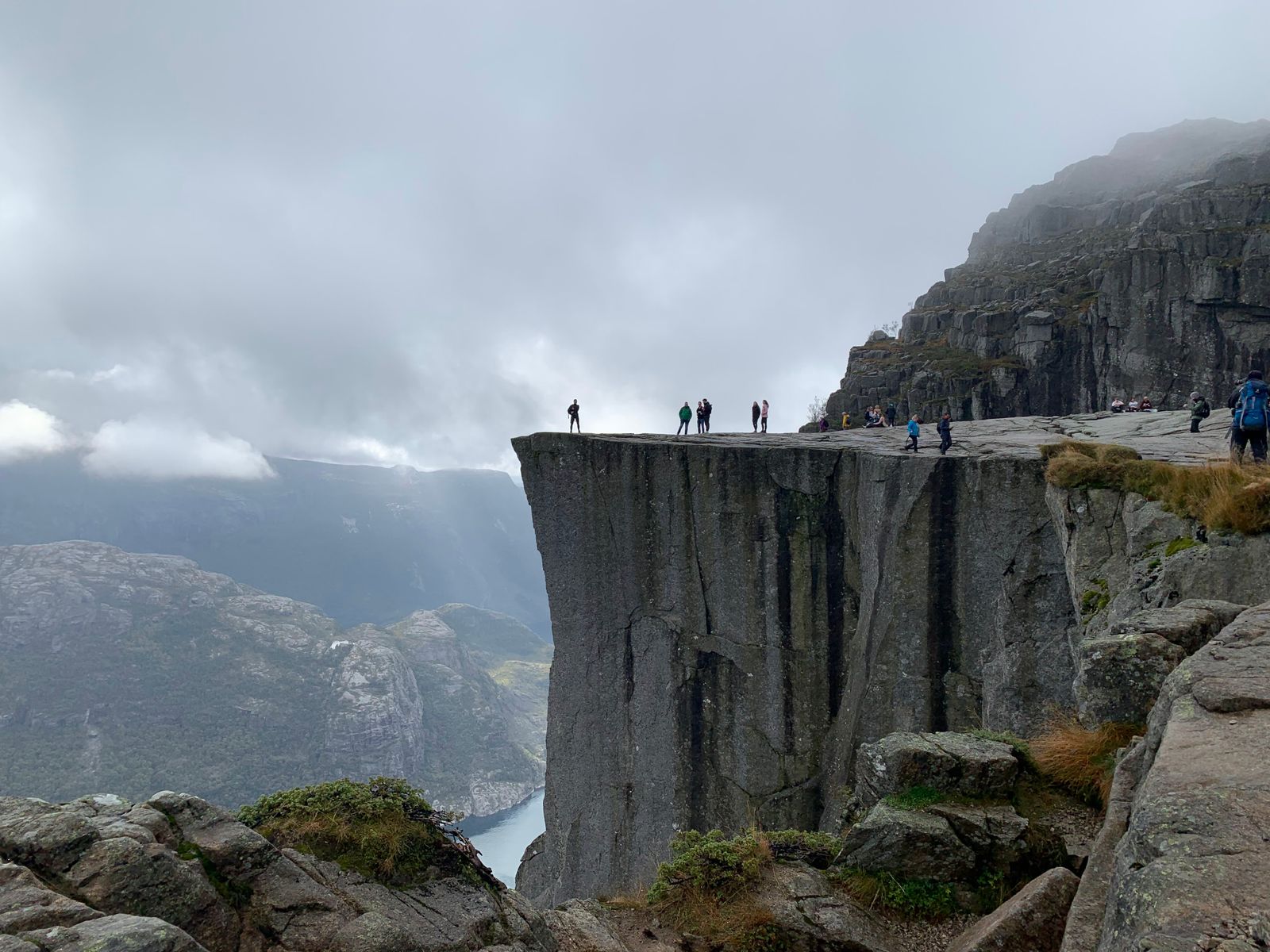 Turgåere på kanten av Preikestolen over Lysefjorden