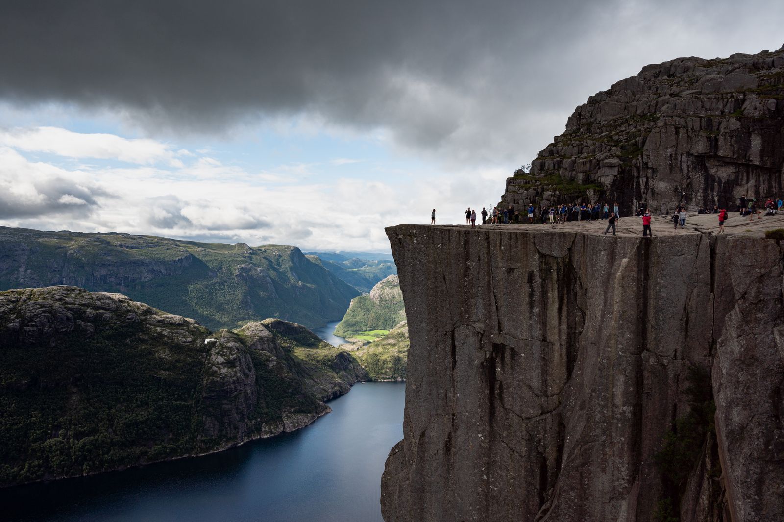 Preikestolen sett fra siden med mørke skyer over Lysefjorden
