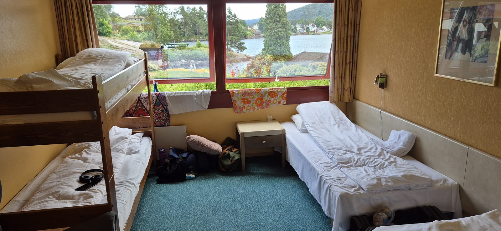 Familierom på Revsnes Hotell med køyeseng, to enkeltsenger og store vinduer med utsikt mot Byglandsfjorden