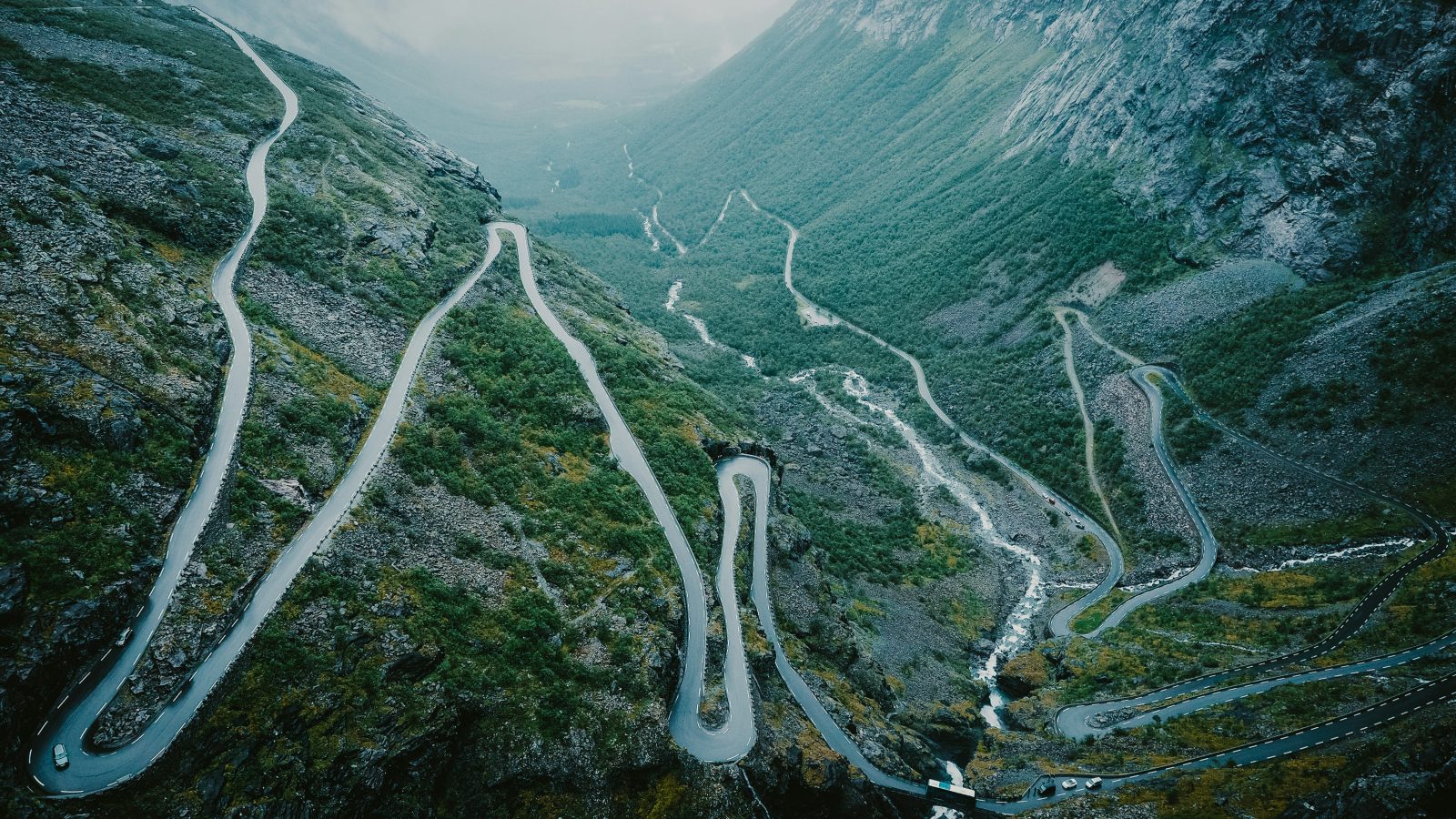 Trollstigen i tåke og lavt skydekke, med de våte hårnålssvingene som forsvinner ned i dalen