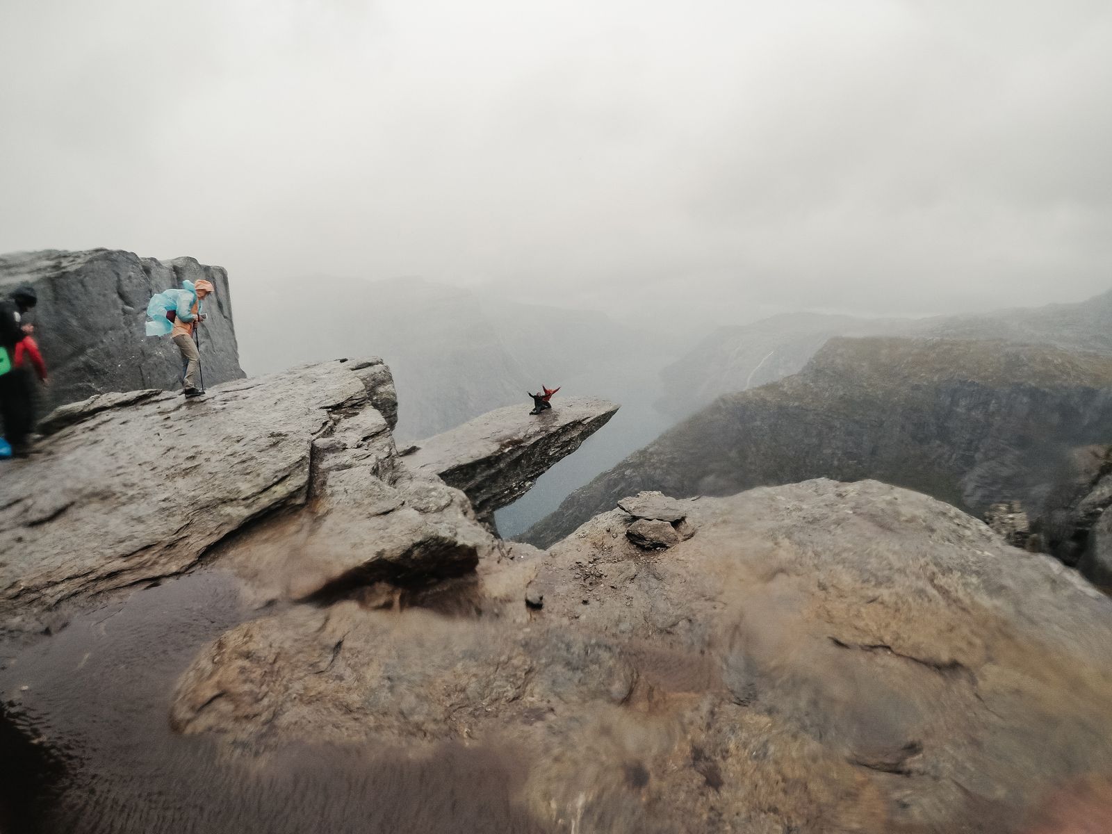 Turgåere ved Trolltunga i tett tåke og regnvær