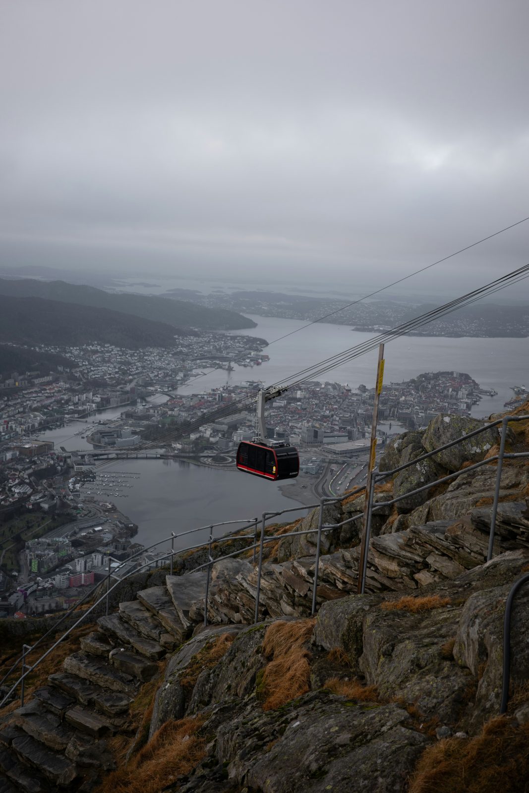 Ulriksbanens vogn svever over fjellsiden med Bergen, Store Lungegårdsvannet og øyene i disen under